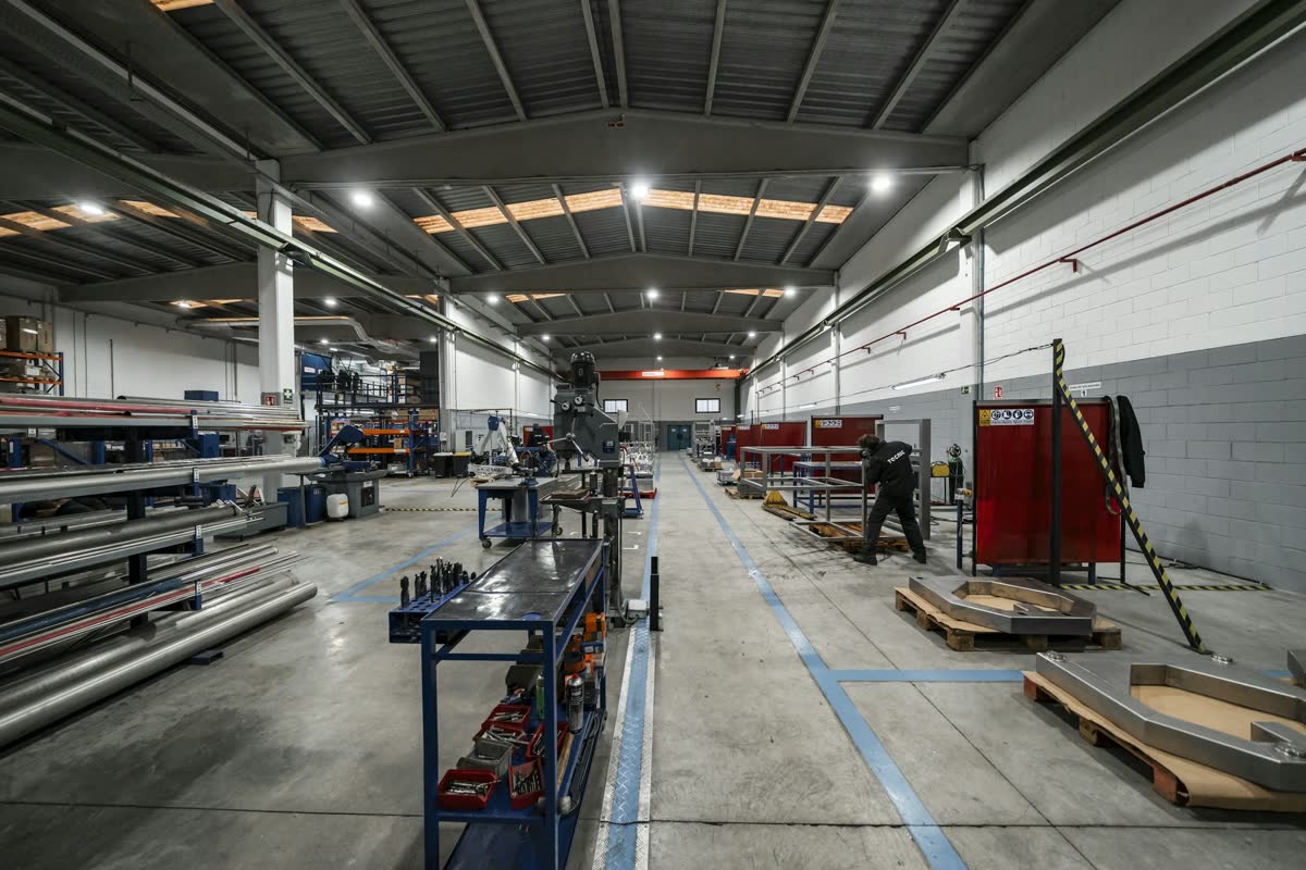 Fertigungshalle mit Materiallager, Arbeitsplätzen und markierten Fahrwegen