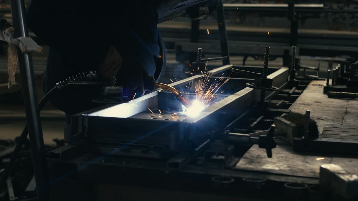 Schweißarbeiten an einem Metallteil in einer Werkhalle (Symbolbild)